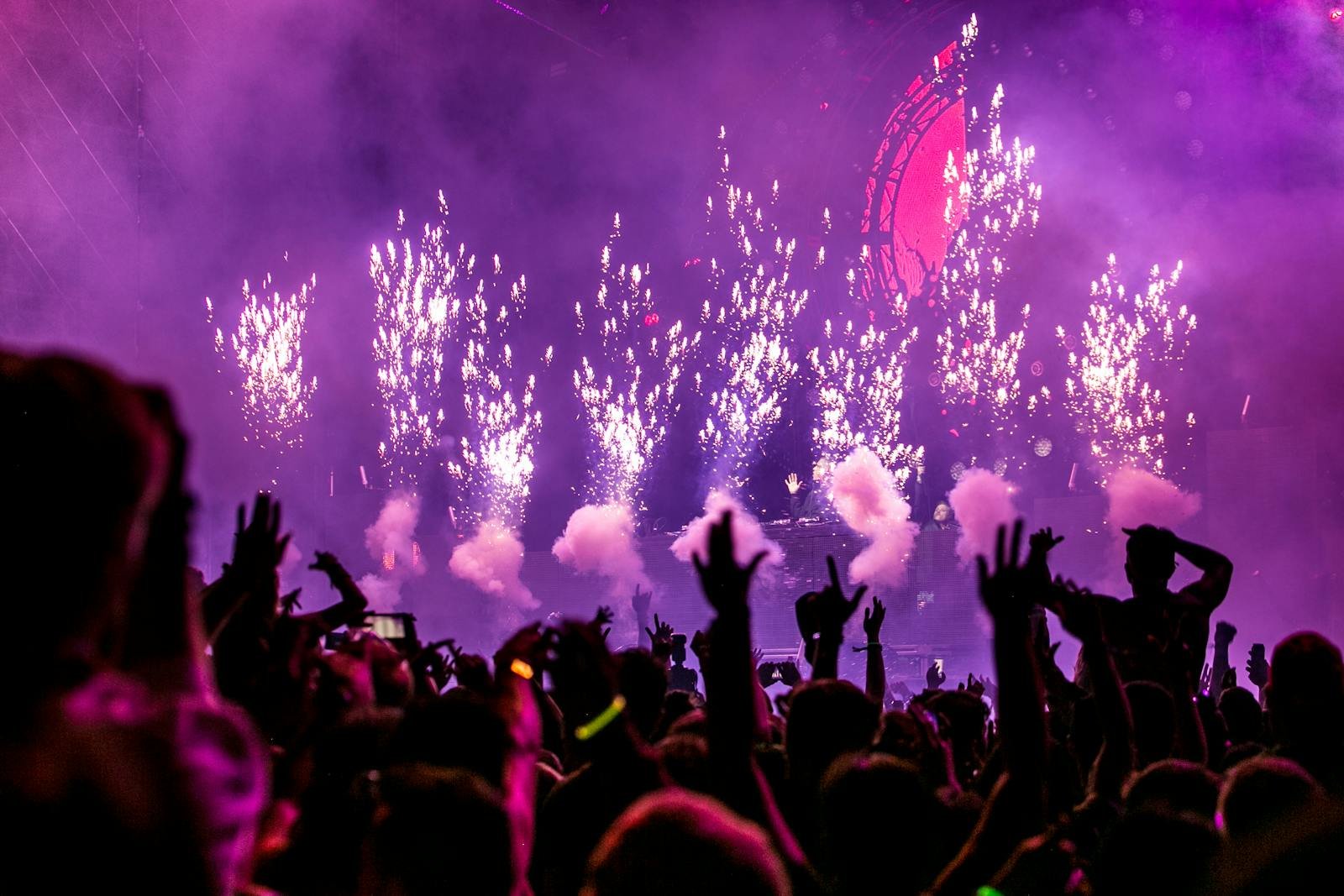 Pub Moriarty Santa Ana - Vibrant EDM concert scene with fireworks, smoke, and enthusiastic crowd enjoying the music.